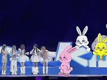 a group of people standing on a stage with a pink bunny in the middle