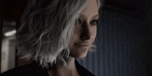 a close up of a woman 's face with white hair and a black jacket