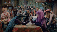 a group of people in pirate costumes are sitting around a table