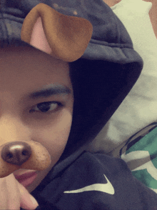 a person wearing a black nike hoodie with a dog nose filter