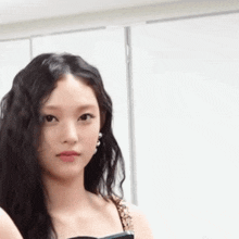 a close up of a woman 's face with long black hair looking at the camera .