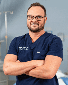 a man in a blue scrub top that says stephen wheat md orthopaedic surgery on it