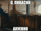 a man in a suit sits on a railing in front of a brewery with russian writing