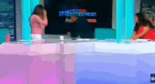 a woman in a pink shirt stands in front of a screen that says ' paintings ' on it