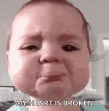 a baby is crying with the words `` my heart is broken '' on his face .