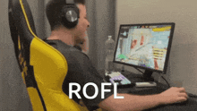 a man wearing headphones sits in front of a computer with the word rofl written on the bottom