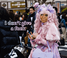 a woman in a pink and purple outfit says i don 't give a fuck in a crowd