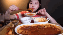 a woman is sitting at a table eating a bowl of soup