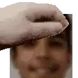 a close up of a person 's face with a hand reaching out to touch it .