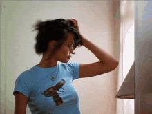 a woman in a blue shirt with a gun on the front