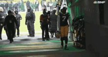 a football player with the number 7 on his jersey walks out of a locker room