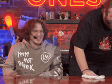 a man wearing a hoodie that says i 'm not drink is smiling