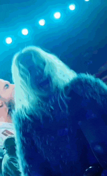 a close up of a person 's ear with blue lights behind them