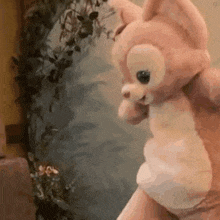 a person is holding a stuffed animal that looks like a cat .