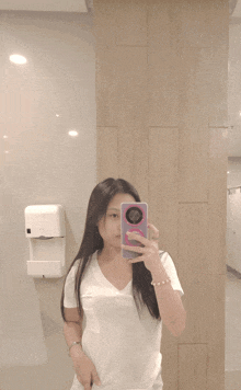 a woman taking a picture of herself in the mirror