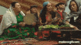 a group of people are sitting around a table with food and playing instruments .
