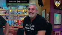 a man wearing a shirt that says xp xa xap the midnight is smiling