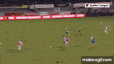a soccer game is being played in a stadium with jupiter league advertisements on the sidelines