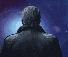 the back of a man 's head is shown with a blue background