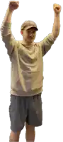 a man with his arms in the air wearing a nike sweatshirt and shorts