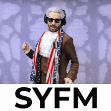 a man in a suit and scarf is standing in front of a microphone with the syfm logo below him