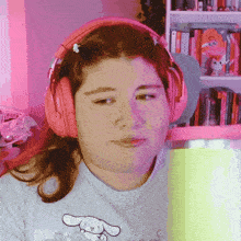 a girl wearing pink headphones and a blue shirt with a bunny on it