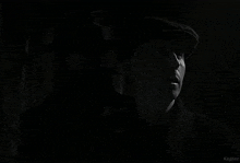 a black and white photo of a man wearing a mask and a hat