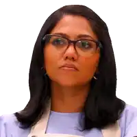 a woman wearing glasses and an apron is making a funny face