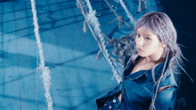 a woman with purple hair is sitting on a rope in a pool