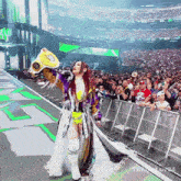 a woman in a purple and gold outfit is holding a wrestling championship belt