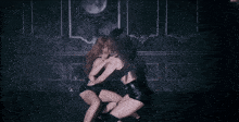 two women are dancing in a dark room