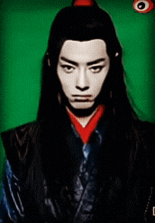 a man with long hair and a red collar is looking at the camera