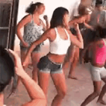 a group of young women are dancing in a room .