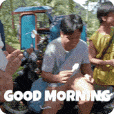 a man sitting on a motorcycle eating an ice cream cone with the words " good morning " written below him
