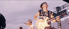 a man playing a guitar with a shirt that says lord