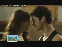 a man and a woman are kissing in a kitchen in a video .