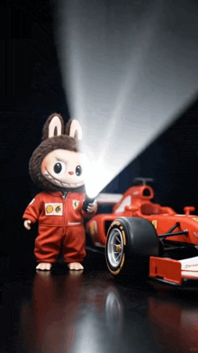 a stuffed animal holding a flashlight next to a red race car