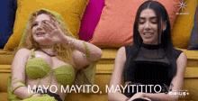 two women sitting on a yellow couch with mayo mayito mayititio written on the bottom