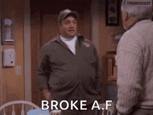 a man in a military uniform is talking to another man in a living room and says `` broke a f '' .