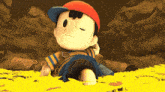 a cartoon character named ness is sitting in a pile of yellow paint