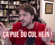 a man in a red shirt with the words ca pue du cul hein
