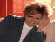 a woman sitting on a couch with a hand on her face