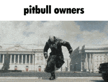 a picture of a man running down a street with the words pitbull owners below him