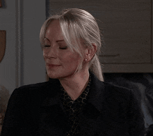 a woman with blonde hair is wearing a black jacket and a leopard print shirt