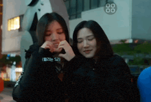 two girls are standing next to each other and one of them has a sticker that says 52