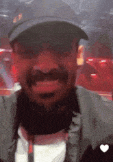 a man wearing a hat and jacket is smiling with a heart in the corner