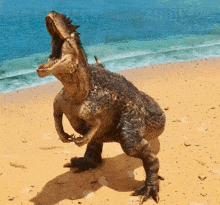 a dinosaur is standing on a beach with its mouth open