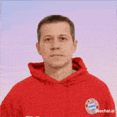 a man wearing a red hoodie with fc bayern munchen on the front