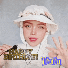 a woman wearing a hat and a hijab says happy birthday