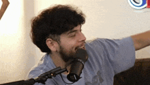 a man with a beard is talking into a microphone .